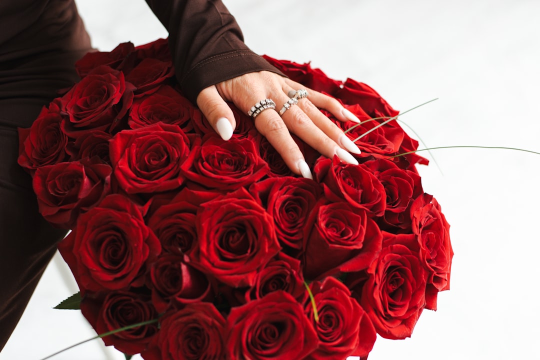 Hand holding a bouquet of red roses.