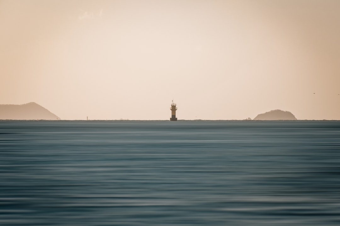 a large body of water with a lighthouse in the distance